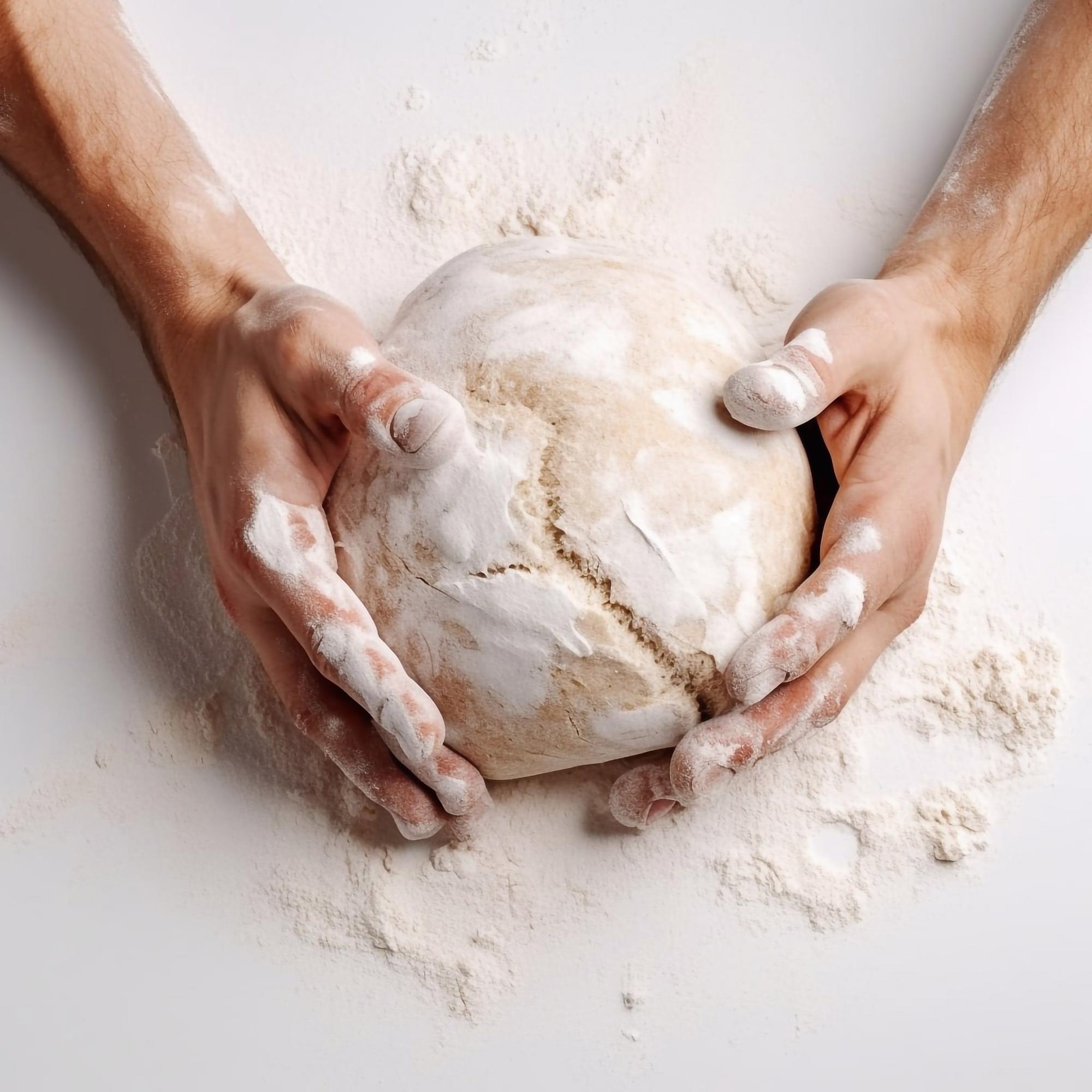 Hands kneading dough in rustic bowl