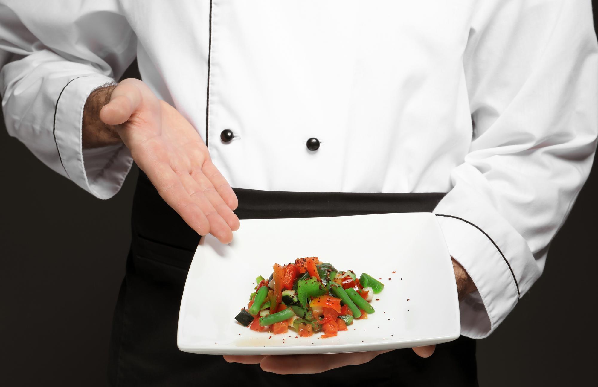 Chef arranging plated dish in luxury kitchen